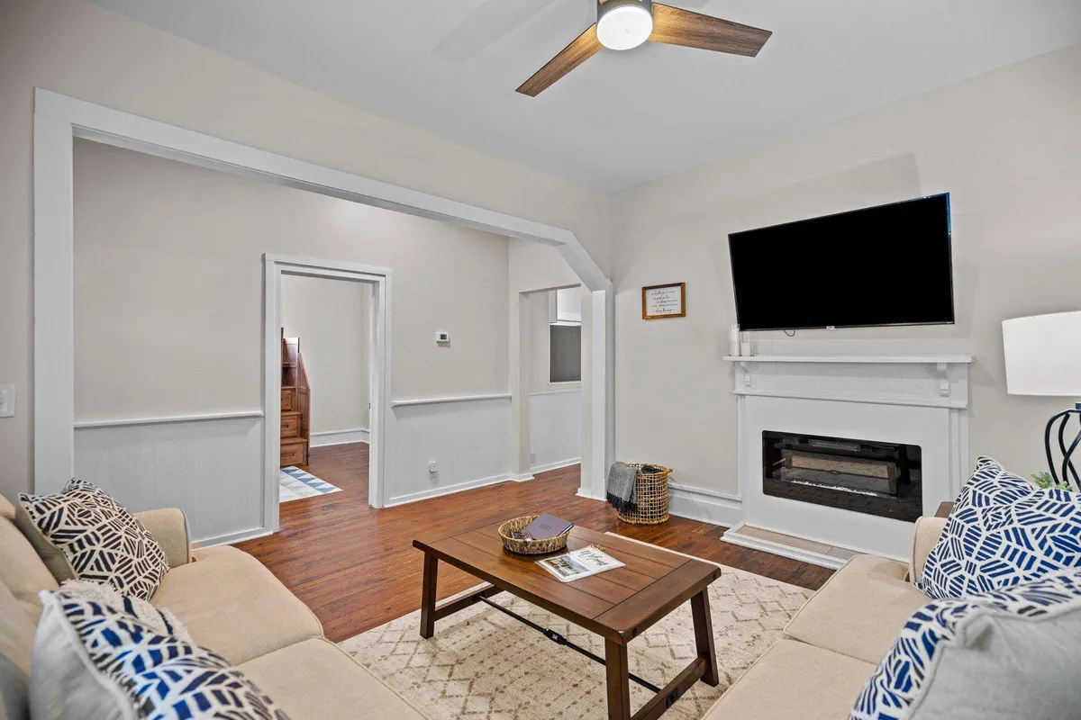 An inviting living room setup featuring a cozy sofa, a fireplace, a coffee table, and a television. The arrangement encourages both group interaction for movie nights and relaxed solo time, perfectly matching the section's promise of a hub for entertainment and relaxation.