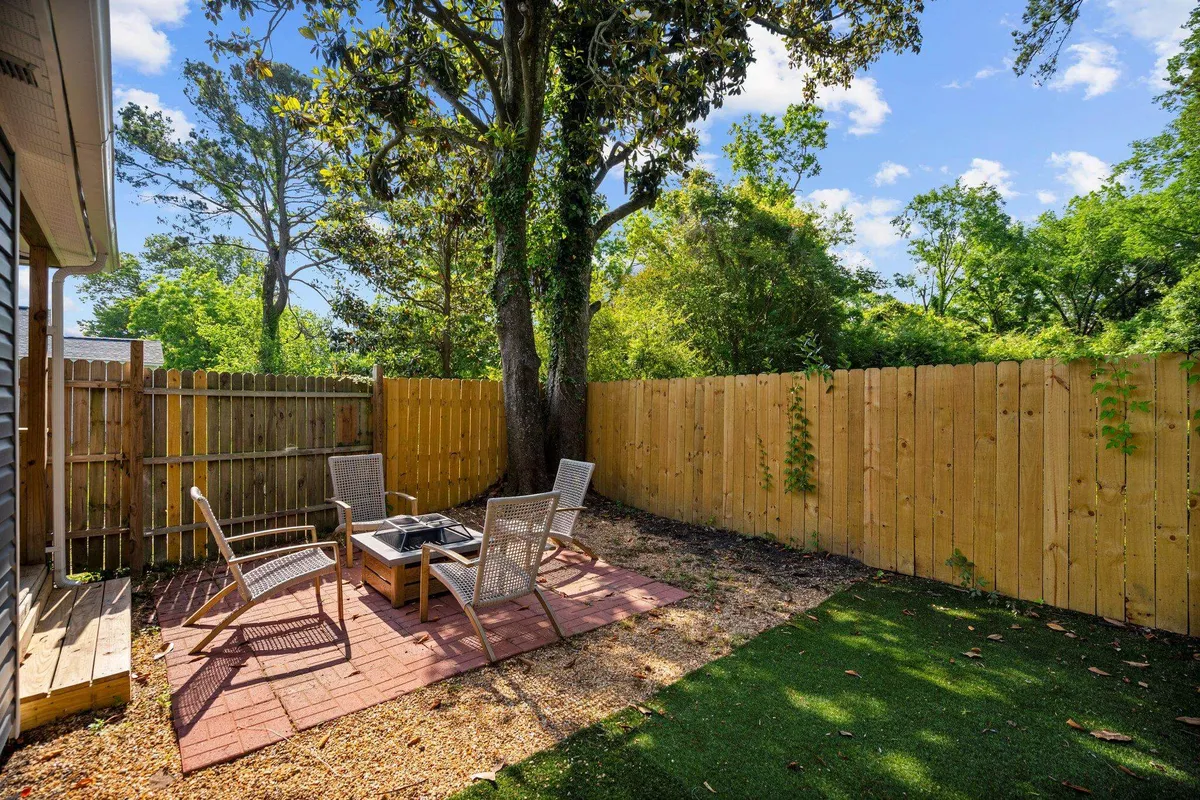 The photo presents an outdoor seating area arranged around a fire pit, embraced by vibrant greenery. The scene exudes a calm, cozy vibe, ideal for stargazing, enjoying morning coffee, or intimate conversations in nature.