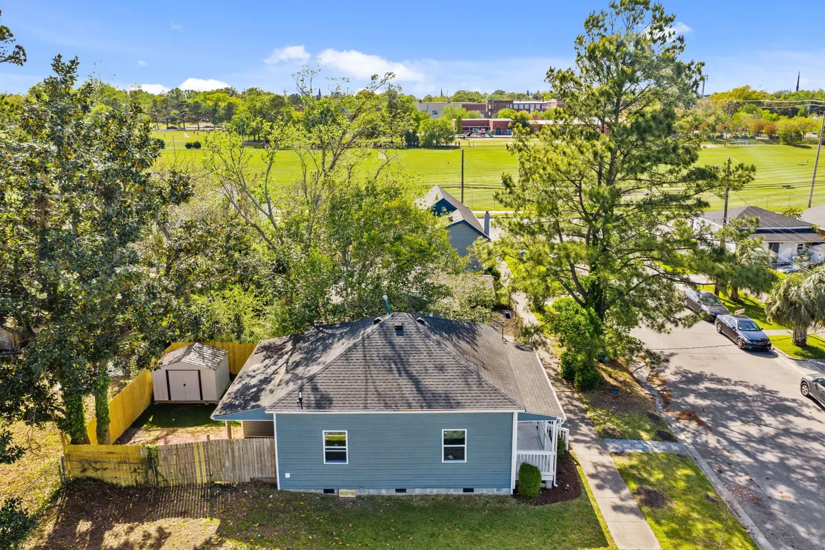 A wider exterior view shows the house nestled among trees with an open field and driveway, suggesting ample outdoor space for gatherings, play, and relaxation. The setting feels serene and safe—ideal for returning from a day of adventures.